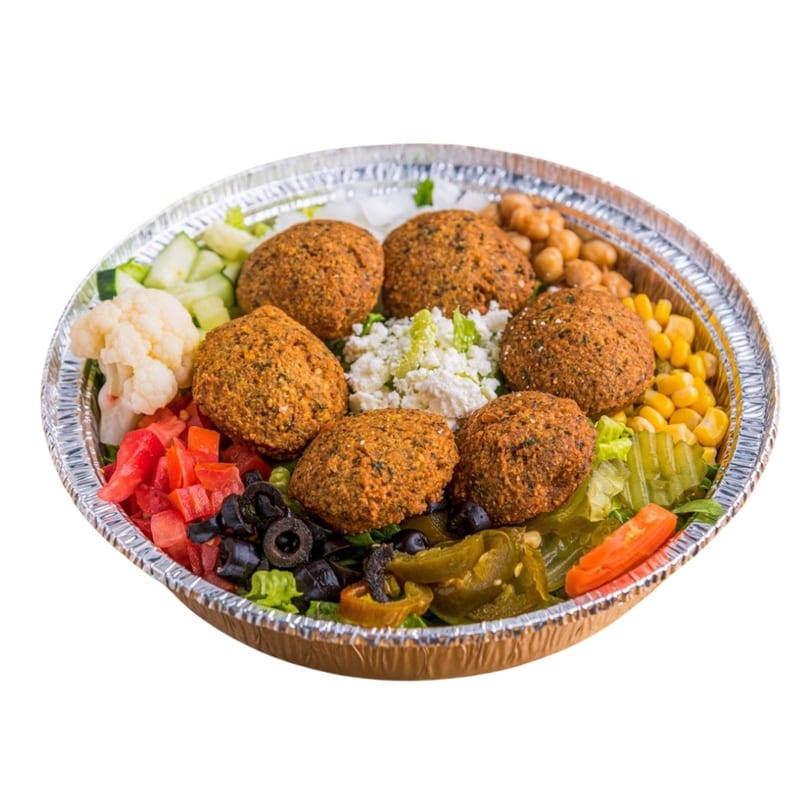 Falafel salad with chickpeas, corn, cauliflower, tomatoes, olives, and jalapenos in a foil bowl.